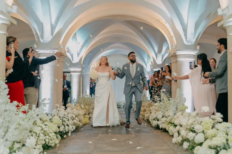 Megan and Karan walking together as guests celebrate their wedding