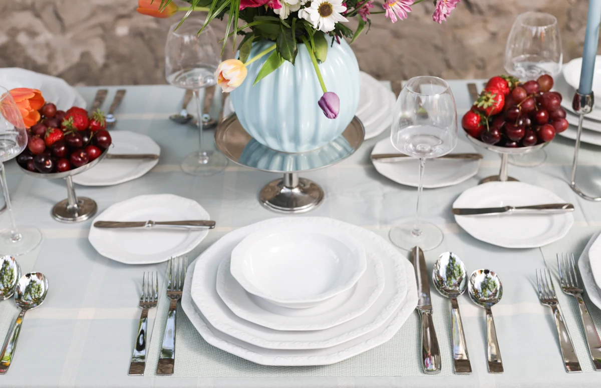 Rosenthal and Sambonet table with a floral centerpiece and porcelain place settings