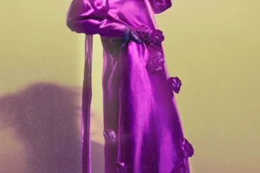Samia Benchaou in a pink dress with a sculptural hat and gloves