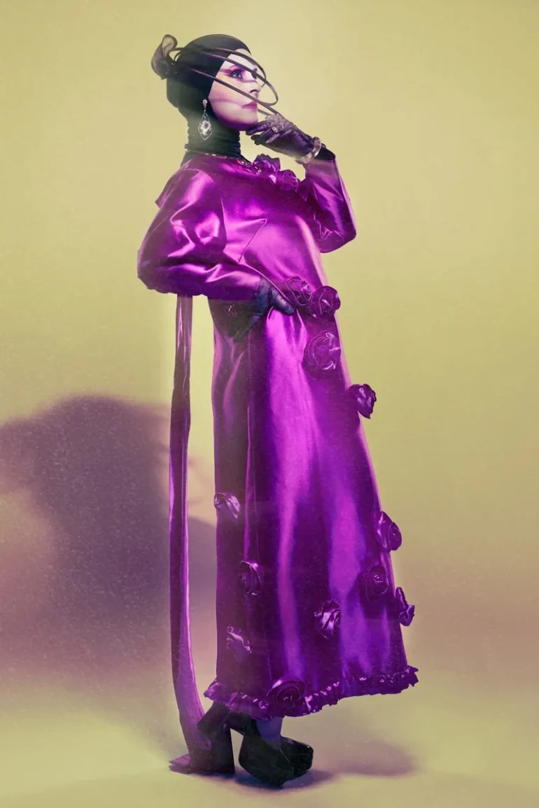 Samia Benchaou in a pink dress with a sculptural hat and gloves