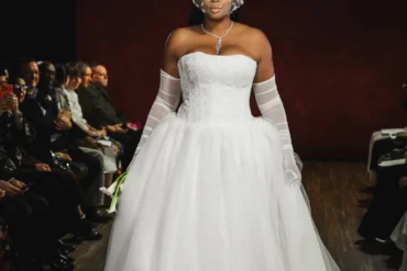 Model in a dramatic white ballgown with opera gloves and an embellished headpiece, Bi Pham Fall 2027