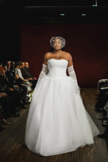 Model in a dramatic white ballgown with opera gloves and an embellished headpiece, Bi Pham Fall 2027