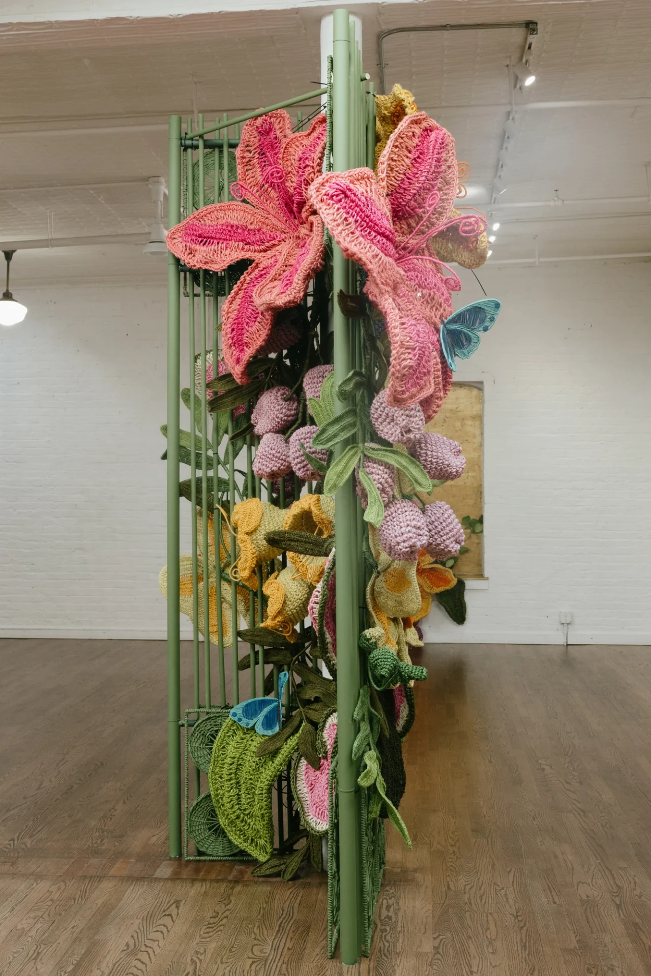 A colorful handwoven flower installation fills the Chelsea presentation space