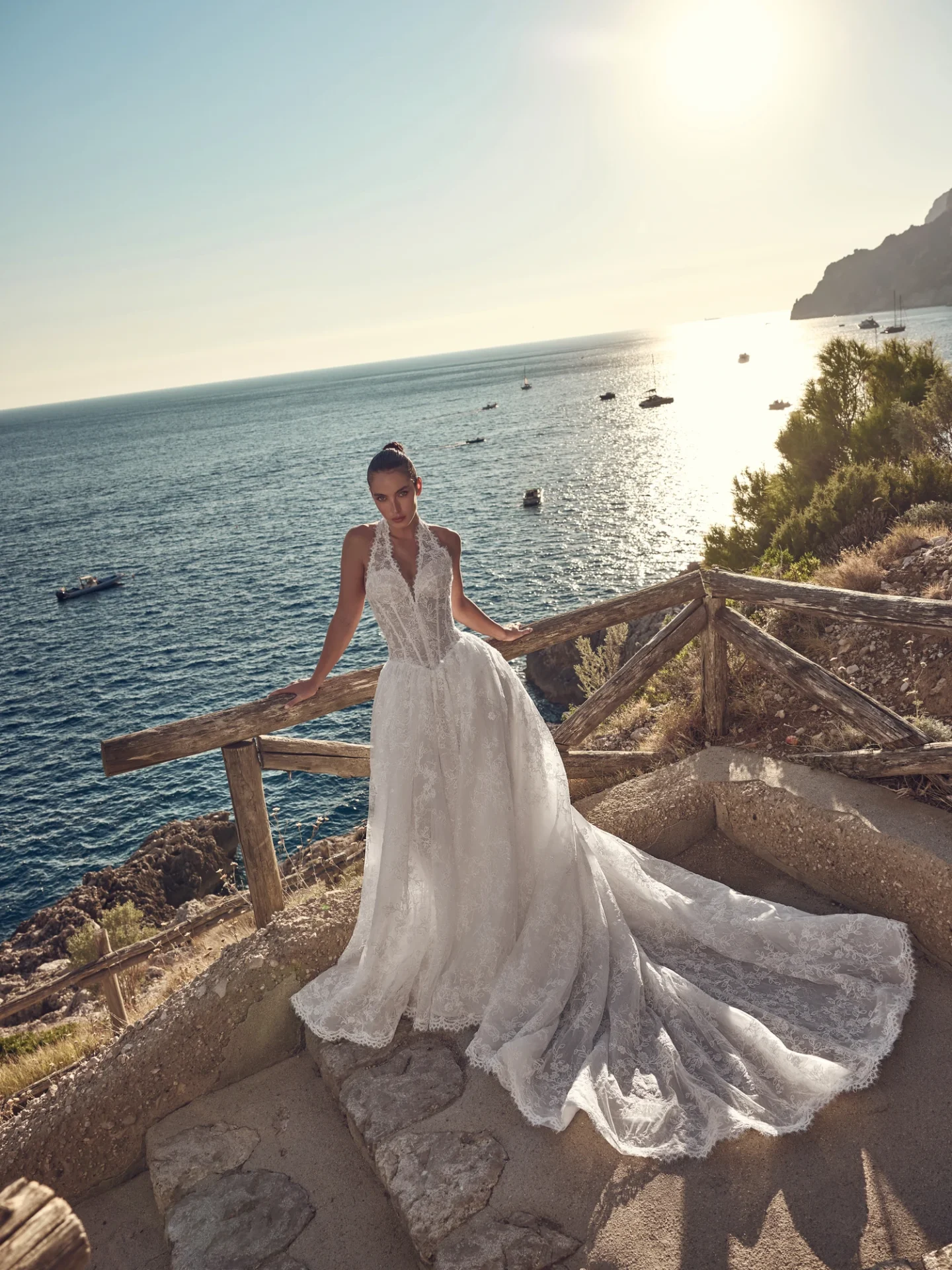 Ricca Sposa Couture Capri 2028 style 28-006, with a plunging lace halter neckline, pointed waistline, and full skirt.
